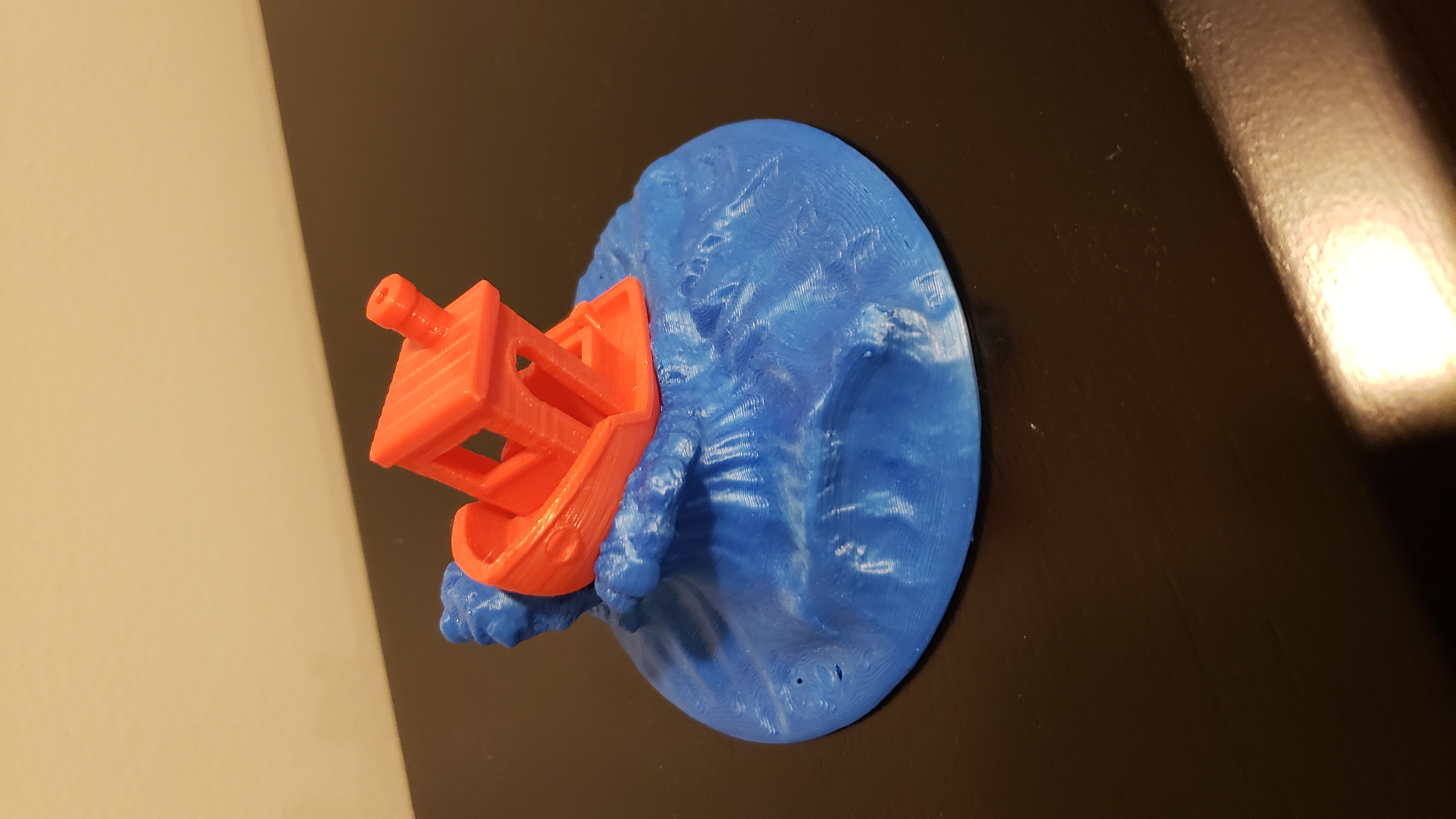 Red benchy boat sitting on a blue wave